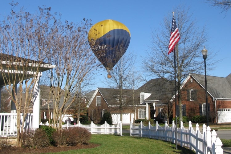 Hot air balloon landing in neighborhood.